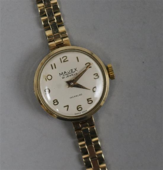A ladys 9ct gold Majex manual wind wrist watch on a 9ct gold bracelet.